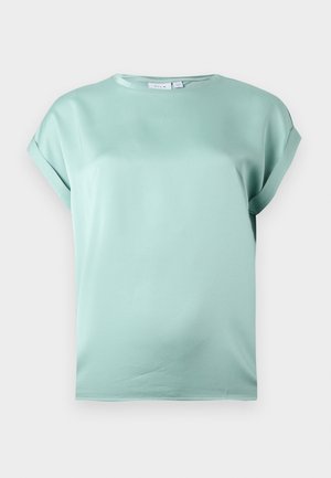 heleheledad lühikeste varrukatega pluus, ümar kaelus ja lahtised keeratud varrukad, ühevärvilisel taustal.