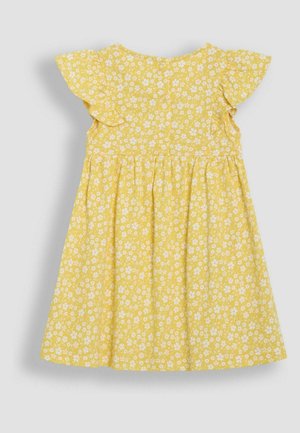 Geltona medvilnės suknelė su balta gėlių spausdintine medžiaga, trumpomis šoninėmis raukinėmis, apvaliu iškirpimu ir surinkta sijonu. Mygtukų uždarymas nugarinėje pusėje.