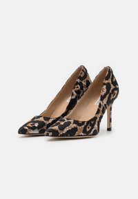 Escarpins en imprimé léopard avec un bout pointu, en tissu noir et or, et un talon aiguille fin. Texture lisse avec une doublure intérieure beige.