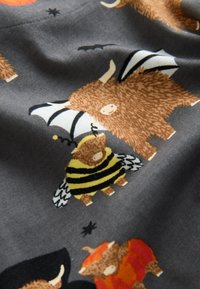 Tissu gris présentant des animaux de dessin animé en différentes tenues, incluant une chauve-souris et une abeille, avec une fourrure texturée et des couleurs vives dans des motifs.