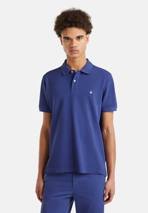 Polo azul marino hecho de algodón, con un collar clásico, tres botones y un logo bordado en el lado izquierdo del pecho.