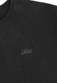 Czarna bawełniana koszulka z okrągłym dekoltem i krótkimi rękawami, z delikatnym szarym logo "Prosto" po lewej stronie.