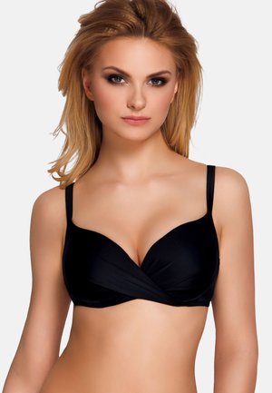 Black bra with a smooth, stretchy material. Features a twisted design at the front, adjustable straps, and a low-cut shape for support.