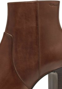 Brauner Leder-Ankelstiefel mit glatter Textur, taillierter Passform und Blockabsatz. Verfügt über gestickte Details und ein dezentes Markenlogo.