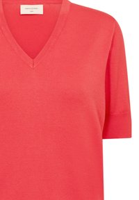Coral V-neck sweater with short sleeves, crafted from a soft, textured knit fabric. Features a clean design with a subtle ribbed finish.