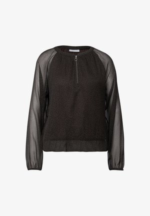 Blouse noire avec un corps en imprimé léopard texturé, des manches longues transparentes, un col rond, et un détail de fermeture éclair à l'avant avec une tirette circulaire.