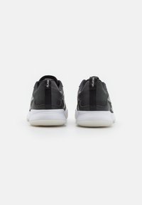 Black and grey athletic sneakers with a smooth texture, round toe, white sole, and pull tabs on the heel. Features side perforations.