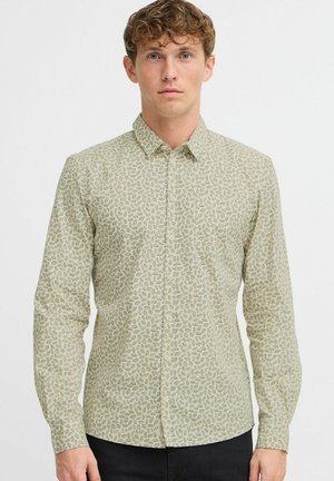 Camicia a maniche lunghe con bottoni di colore verde chiaro e motivo a foglie. Realizzata in un tessuto morbido, presenta un colletto classico e polsini con bottoni.