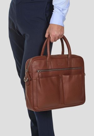 Brown leather briefcase with grainy texture, double handles, and front pockets. Zipper closure and rectangular shape.
