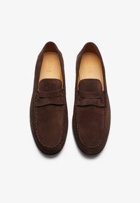 Braune Wildlederschuhe mit einem gestickten Design und einer Schleifenakzent an der Vorderseite. Glatte Textur mit einer runden Zehenform und flacher Sohle.