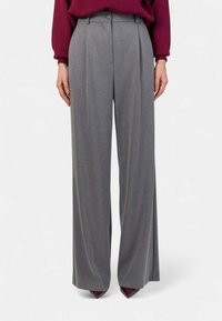 Pantaloni grigi su misura con un design a gamba ampia, realizzati in un tessuto morbido. Presentano pieghe frontali e una vita con passanti per cintura.