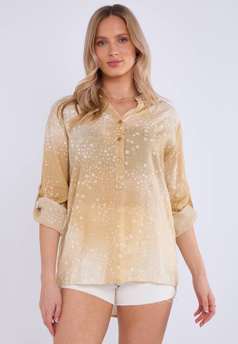 Camicia dorata chiara con motivo a stelle, tessuto morbido, apertura con bottoni, maniche arrotolabili e vestibilità comoda. L'orlo è più lungo sul retro.