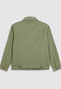Veste à manches longues vert clair vue de dos avec poignets boutonnés, pattes de réglage à la taille et détails de couture visibles.