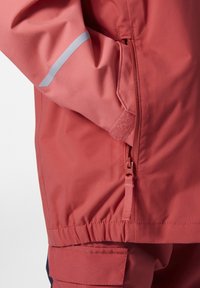 Chaqueta impermeable en color coral con un bolsillo lateral con cremallera, cintura elástica y detalles reflectantes en la manga para mayor visibilidad.