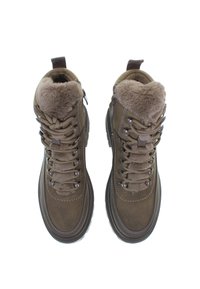Bruna mockaskinnsvandringsskor med fuskpälsfoder, vadderad krage, metallöglor och texturerad gummisula. Snörning för en säker passform.