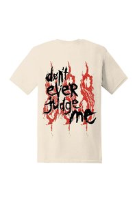 Beżowy bawełniany t-shirt z czarno-czerwonym nadrukiem na plecach, z motywem przypominającym płomień podkreślającym napis "nigdy mnie nie oceniaj".