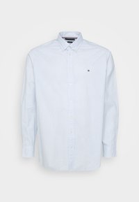 Vaaleansininen puuvillainen nappipaita, jossa on hienovarainen kuvio, pitkät hihat ja pieni logo rintakehän alueella.