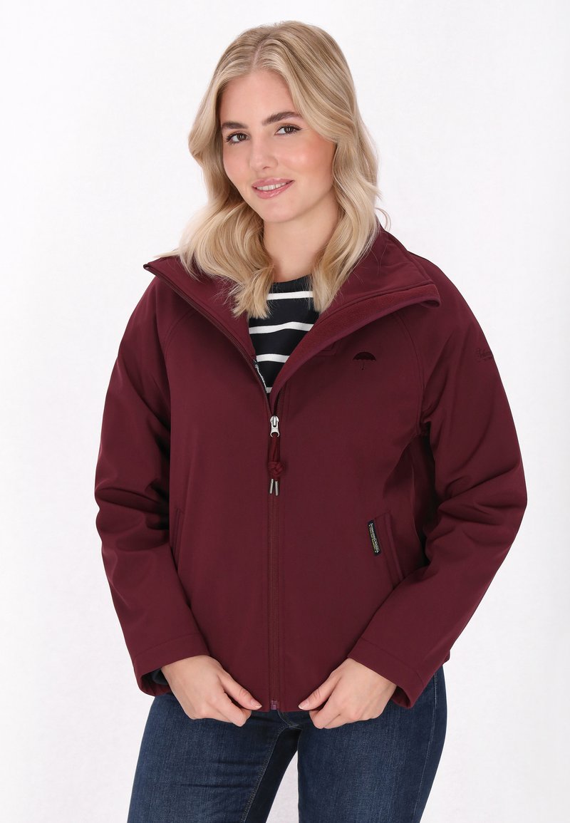 Bordo zip-up striukė su aukštu kaklu, reguliuojamu raiščiu, šoninėmis kišenėmis ir lygia tekstūra. Sukombinuota su juostuotu marškinėliu ir džinsais.