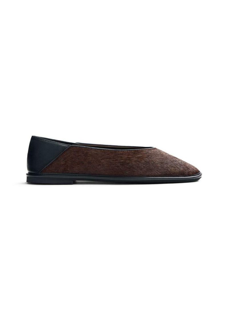 Scarpa piatta con una tomaia marrone, testurizzata e simile ai capelli, e un tacco in pelle nera liscia. Presenta una punta arrotondata e un design minimalista.