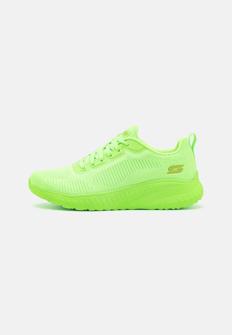 Chaussure de sport vert néon vif avec dessus en maille, fermeture à lacets, semelle rembourrée et petit logo doré sur le côté, vue de profil.
