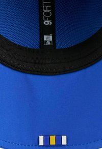 Blaue Kappe mit schwarzem Rand, ausgestattet mit einem Mesh-Innenfutter und einem kleinen, mehrfarbigen Akzent nahe des Schirms: blaue, gelbe und weiße Streifen.
