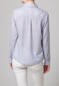 Langsleeve shirt met een lichtblauw en wit gestreept patroon, met een button-down kraag en een afgeronde zoom, gemaakt van een lichtgewicht stof.