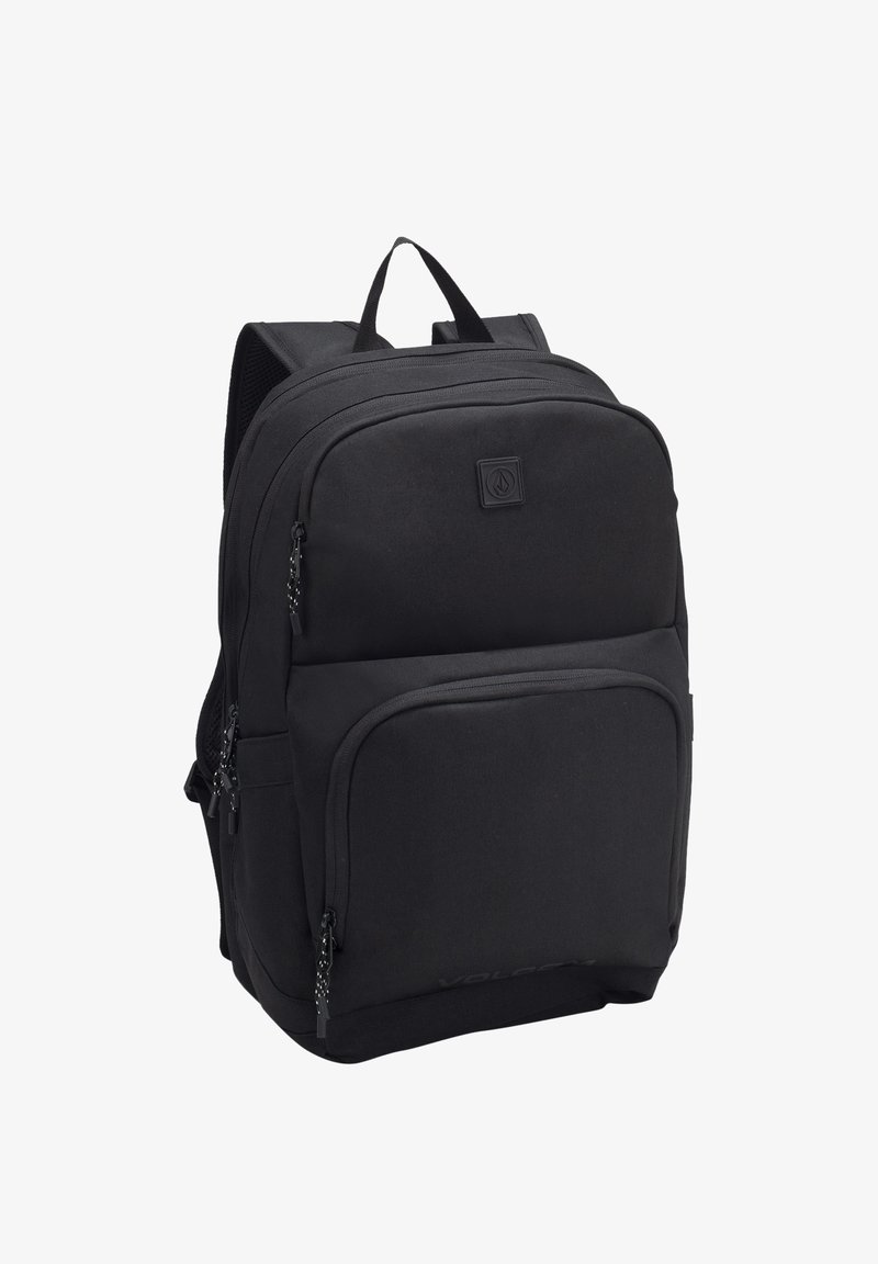Zaino nero con numerose tasche con zip, spallacci imbottiti e materiale testurizzato. Presenta un logo sulla parte anteriore.