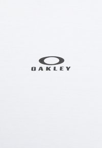 White T-shirt made of cotton featuring a black "OAKLEY" logo with an oval accent in the center. Smooth texture and short sleeves.