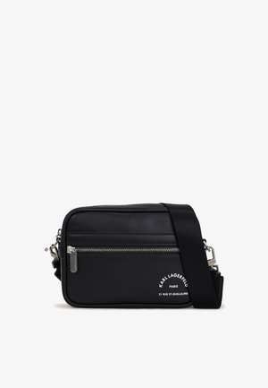 Bolso cruzado sintético negro con cremallera plateada, correa ajustable y un estampado de logo. Presenta una forma rectangular y una textura suave.