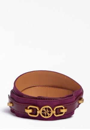 Paarse suède en leren riem met gouden metalen logo en gespdetails, opgerold tegen een witte achtergrond.