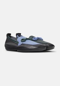 Modische Slipper aus einer Kombination von schwarzem, blauem und grünem Leder, mit dekorativen passenden Schleifen auf jedem Schuh.