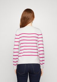 Maglione a righe bianco e fucsia, realizzato in un materiale morbido. Collo rotondo, maniche lunghe, orlo a costine e vista posteriore mostrata.