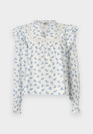 Gaiši zila ziedu blūze ar volānu piedurknēm, V veida izgriezumu un savelkamu aproces detaļām. Izgatavota no mīksta auduma ar vieglu tekstūru.