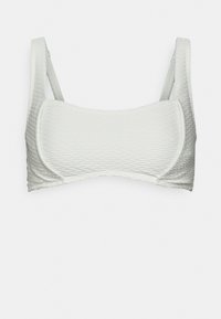 Bralette branco texturizado com um design sem costuras, alças largas e uma forma ligeiramente arredondada, com um forro interior suave.
