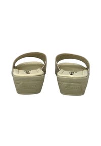 Sandali platform beige con suola texturizzata, parte posteriore aperta e cinturino regolabile. Presentano un logo impresso sul tallone e un plantare morbido.