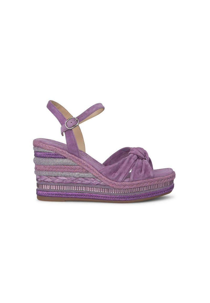 Sandali a zeppa in suede viola con un davanti annodato, cinturino alla caviglia regolabile e dettagli della piattaforma intrecciati in diverse texture.