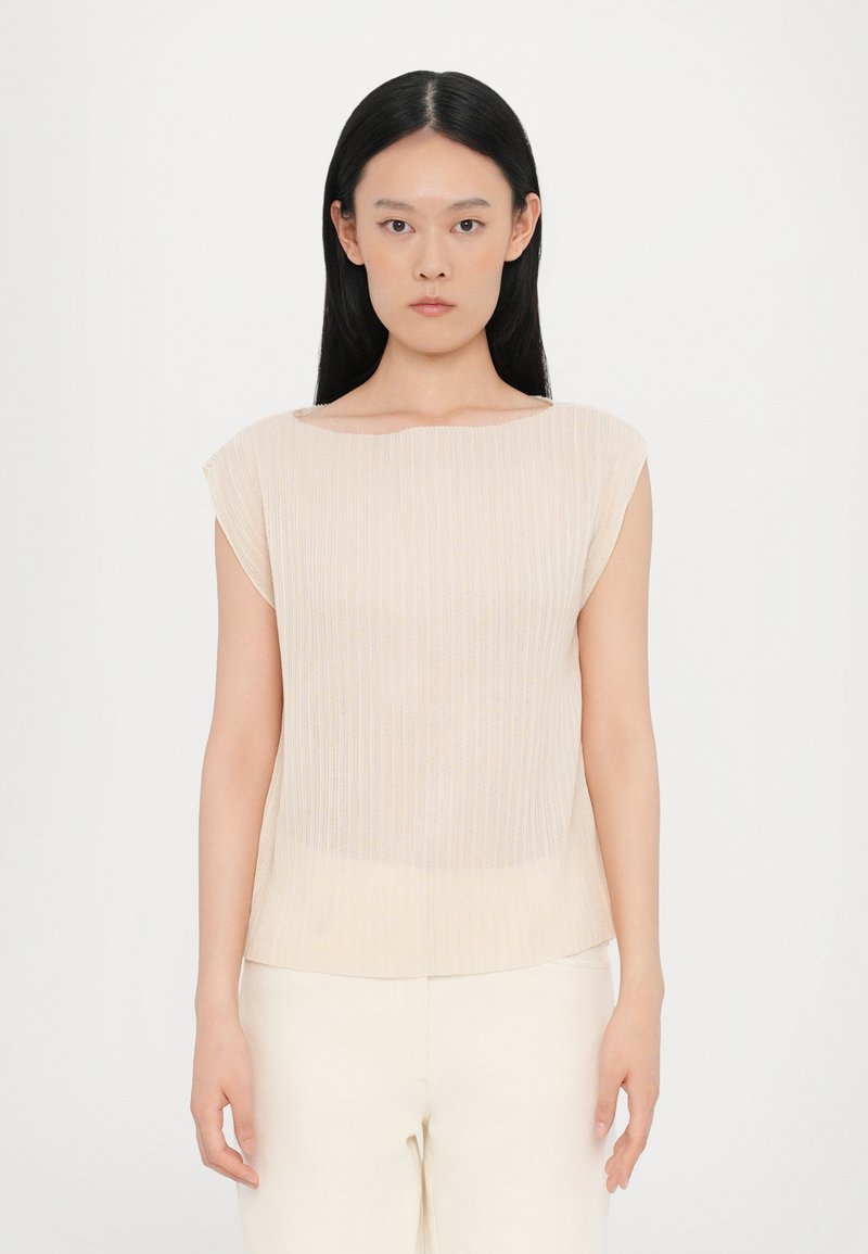 Light beige sleeveless top made of textured fabric with subtle vertical stripes; features a wide neckline and straight hem.