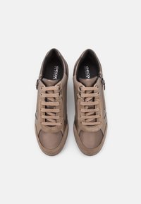 Paire de baskets décontractées Geox Respira beige avec lacets et fermeture éclair latérale vue de dessus sur fond blanc.