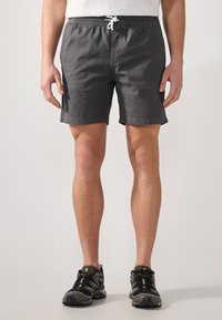 Bañador gris con cintura elástica y cordón blanco. Fabricado con tejido ligero, cuenta con bolsillos laterales y un corte relajado.