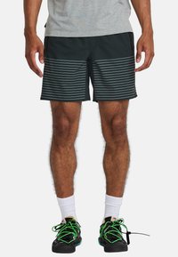 Zwarte shorts met horizontale grijze strepen, gemaakt van lichtgewicht materiaal, met zijzakken en een broekband met trekkoord, gecombineerd met zwarte schoenen.