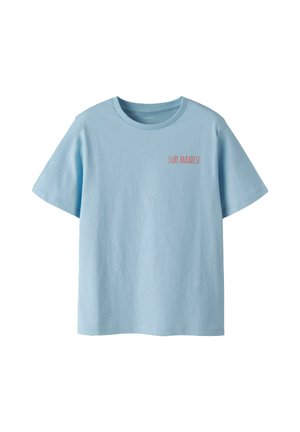 T-shirt bleu clair à manches courtes avec col rond et petit texte rouge "SURF PARADISE" sur le côté gauche de la poitrine.