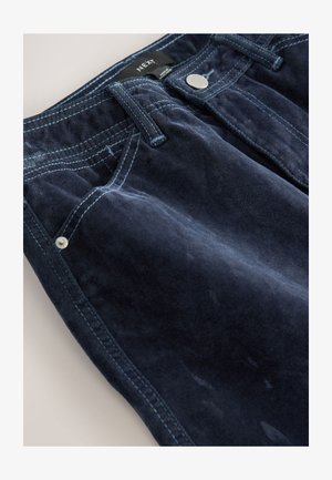 Granatowe spodnie z sztruksu w klasycznym stylu z pięcioma kieszeniami, ze szwami w tonacji oraz metalowymi detalami na pasku.