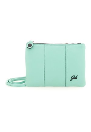 Piccola borsa a tracolla in pelle verde pastello con tre cuciture verticali, cerniera nera e una sottile tracolla arrotolata accanto.