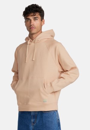 Beiger Hoodie mit Kängurutasche, Kapuze mit Kordelzug und Raglanärmeln. Der Stoff ist weich und hat eine glatte Textur. Kurzer Saum.