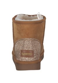 Brauner Wildleder-Stiefelette mit einer strukturierten, glitzernden Akzentuierung an der Ferse. Verfügt über eine weiße Zuglasche und eine weiche, flauschige Innenausstattung.