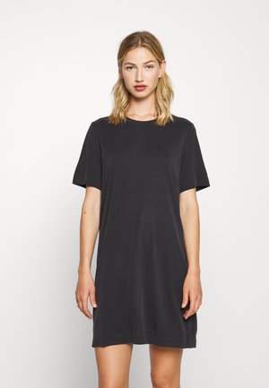 Vestido de t-shirt em algodão preto com mangas curtas, decote redondo e um corte relaxado. Textura suave, comprimento até ao joelho.