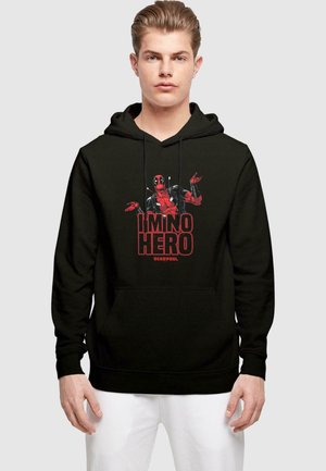 Svart hettegenser med frontlomme, prydet med et grafikk av Deadpool og teksten "JEG ER IKKE EN HELT" i rødt. Myk stoff, lange ermer, justerbar hette.