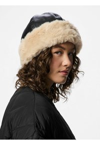 Černý kožený klobouk s měkkým béžovým kožíškem. Design má zaoblený tvar a viditelné švy na vrchu.