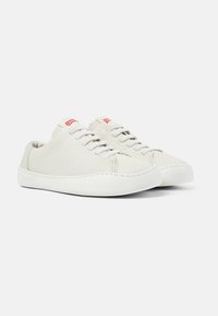 Hellbeige Leder-Sneaker mit runder Zehenpartie, weißer Gummisohle und grauen Schnürsenkeln. Mit einem roten Logotag auf der Zunge.