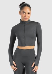 Mørkegrå cropped atletisk jakke med lange ærmer og høj krave, der har en frontlynlås og en glat, strækbar stofstruktur.